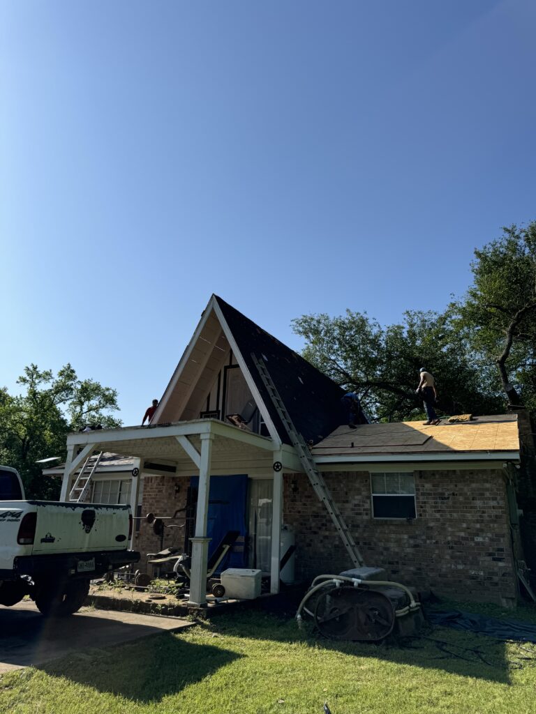 Workers repairing a house roof
